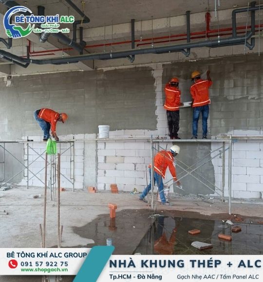 Thợ thi công hoàn thiện bề mặt vách ngăn cháy panel ALC có lõi thép bằng giàn giáo tại nhà xưởng