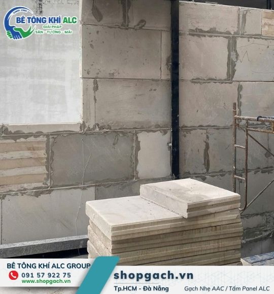 Tường gạch nhẹ khổ lớn xây sát cột thép, kiện gạch tập kết bên cạnh