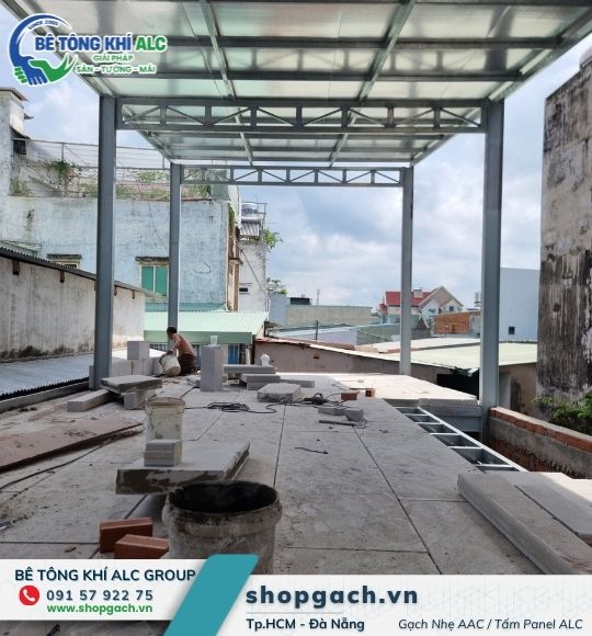 Khung thép dựng trên mái nhà cũ, gạch nhẹ tập kết để xây tường tầng mới